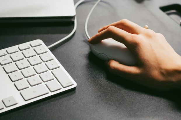 Person using a mouse and keyboard while reviewing email campaign data